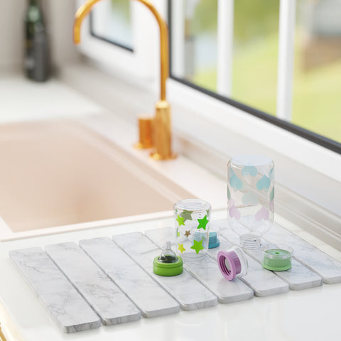 Diatomaceous earth drying mat with baby bottles near kitchen sink
