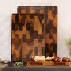 Two wooden acacia cutting boards with a geometric pattern on a kitchen counter.