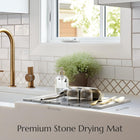 Stone dish mat slate gray Kitchen sink area with a stone drying mat, gold faucet, and decorative elements.